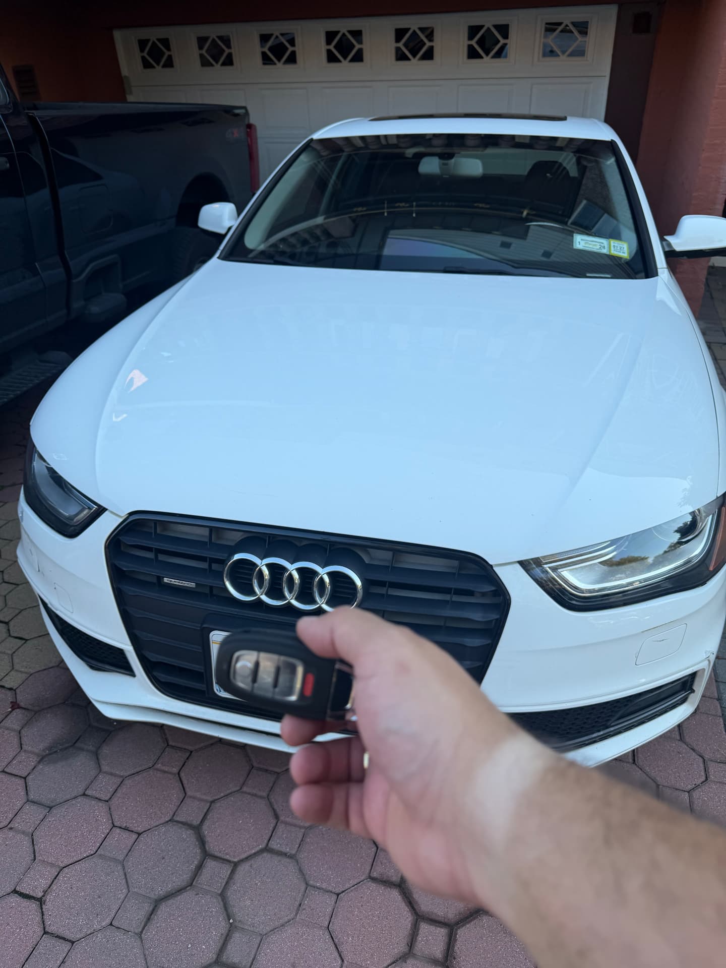 Programmed Audi remote key held in front of a white Audi
